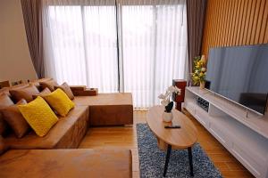 a living room with a couch and a television at Nattarin Pool Villa Pattaya-Na Chom Thian in Ban Map Fakthong
