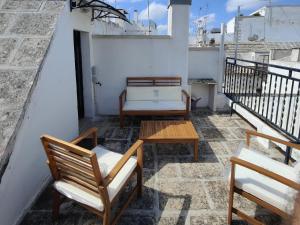 a balcony with two chairs and a table and a couch at Maisonette 4-Room Roof Top in Centro Storico in Martina Franca