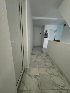 een hal met een marmeren vloer en een witte muur bij Vila Yzabelle in Eforie Nord