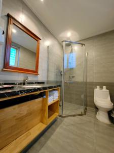 een badkamer met een wastafel, een toilet en een douche bij Beidaihe No. 3 Jinhai in Qinhuangdao