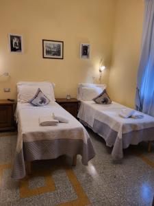 twee bedden in een kamer met ermottermott bij BnB Villa Melany vicino Centro in Lucca