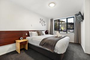 a bedroom with a large bed and a window at 5 Min Stroll into Town Centre - No Hills in Queenstown