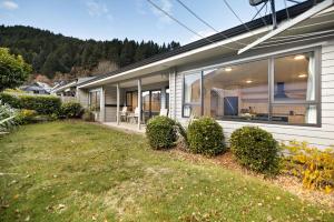 a house with a yard in front of it at 5 Min Stroll into Town Centre - No Hills in Queenstown