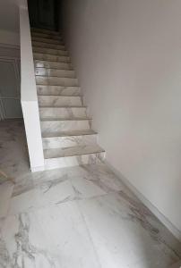 een trap in een kamer met witte muren en marmeren vloeren bij Vila Yzabelle in Eforie Nord
