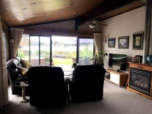 a living room with two chairs and a fireplace at Lakeside Retreat in Hamilton
