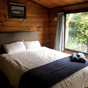 a bedroom with a bed with two pairs of shoes on it at Lakeside Retreat in Hamilton