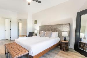 Schlafzimmer mit einem großen weißen Bett und einer Bank in der Unterkunft CozySuites at Kierland Commons with pool#15 in Scottsdale