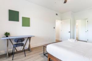 ein Schlafzimmer mit einem Bett und einem Schreibtisch mit Stuhl in der Unterkunft CozySuites at Kierland Commons with pool#15 in Scottsdale