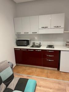 Leonardo's Sweet Hotel في Tappenbeck: مطبخ بدولاب بيضاء ومغسلة وأريكة +61 صورة