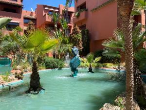 a pool in a resort with a statue in the water at Don Carlos Marbella Beach in Marbella