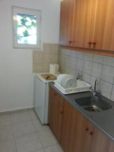 a kitchen with a sink and a washing machine at Vintage House-Vori-Rent Rooms in Vóroi