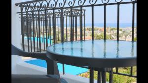 einen Tisch auf einem Balkon mit Poolblick in der Unterkunft Planet View in Faliraki