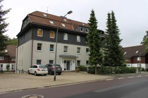 ein großes Gebäude mit davor geparkten Autos in der Unterkunft Talstation in Braunlage