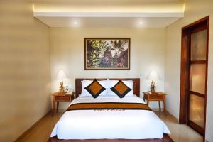 a bedroom with a white bed with two night stands at Dapha Eco Lodge Lovina in Lovina