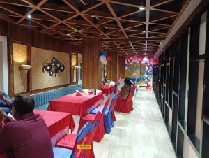 een rij tafels in een restaurant met rood en blauw bij Hotel Ekta International in Deoghar