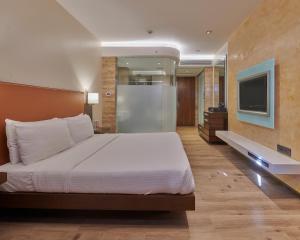 sypialnia z dużym łóżkiem i telewizorem w obiekcie Hotel Residency Andheri w Bombaju