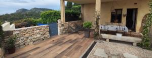 a porch of a house with a wooden deck at La maison d'Yvette - Gîte avec piscine, terrasse privée et vue in Le Barroux