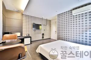 a room with a bed and a table and chairs at Ignis Hotel in Busan