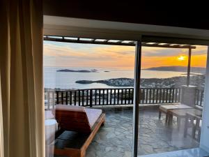 a room with a balcony with a view of the ocean at PANORAMIO in Batsi