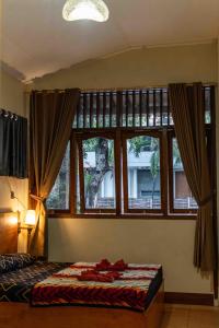 1 dormitorio con cama y ventana grande en Sleepy Raccoon Hostel, en Yogyakarta