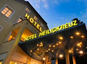 a hotel building with a neon sign on it at Austria Classic Hotel Heiligkreuz in Hall in Tirol