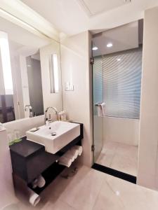ein Bad mit einem Waschbecken und einer Dusche in der Unterkunft Holiday Inn Shanghai Pudong, an IHG Hotel in Shanghai
