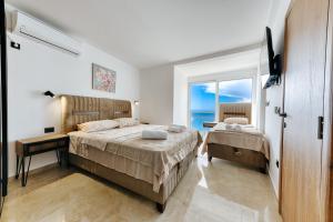 a bedroom with two beds and a view of the ocean at Resort Stikovic in Dobra Voda
