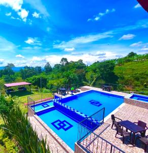 uma imagem de uma piscina numa casa em Hotel Campestre Atardecer Cafetero em Quimbaya