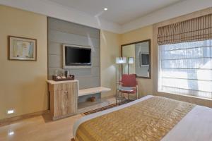 a hotel room with a bed and a television at Residency Hotel Fort in Mumbai
