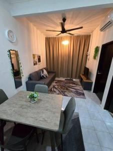 a living room with a table and a couch at Trio Homestay at Tanah Merah in Tanah Merah