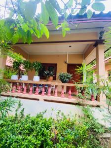 a house with potted plants on a balcony at Mandala bungalow at Ya Nui beach in Rawai Beach