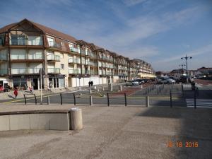 a city street with a building and cars parked at Appartement Ste Cécile à 50 mètres de la plage in Sainte-Cécile-Plage