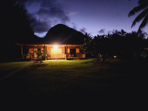 Una casa de noche con la luz encendida en Moanaiti Lodge, en Maheva