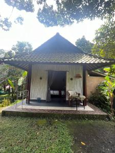 a gazebo with a table and a chair at Khrisna Hs and Cottages in Sidemen