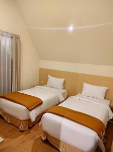 duas camas sentadas uma ao lado da outra num quarto em Hotel Nature Bromo and Resort em Pasuruan