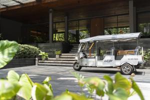 a white golf cart parked in front of a building at Ad Lib Hotel Bangkok in Bangkok