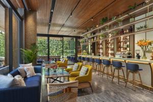 - un hall avec un bar doté de canapés et de chaises bleus dans l'établissement Ad Lib Hotel Bangkok, à Bangkok