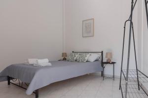 a white bedroom with a bed with two pillows at Muses_Eratw,Chios in Karfas