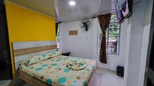 Un dormitorio pequeño con una cama y una ventana. en Hotel la garza roja, en Villavicencio