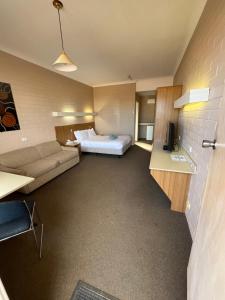 una camera d'albergo con letto e divano di Opal Inn Hotel, Motel, Caravan Park a Coober Pedy