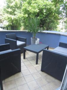 a patio with chairs and a table and a potted plant at Ferienwohnung Mosel-Rhein in Koblenz