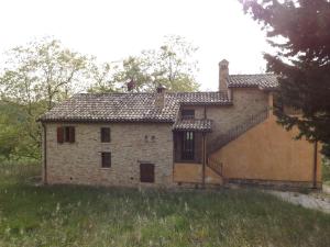 an old brick house with a staircase in a field at Piccolo Gesto d'Affetto in Ripe