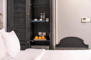 a bedroom with a bed and a plate of oranges on a shelf at Amara Hanoi Hotel and Spa in Hanoi