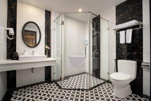 a bathroom with a shower and a toilet and a sink at Amara Hanoi Hotel and Spa in Hanoi