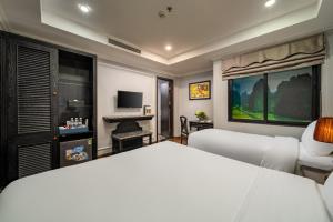a bedroom with a white bed and a desk at Amara Hanoi Hotel and Spa in Hanoi
