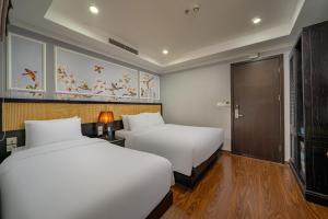 a hotel room with two beds and a door at Amara Hanoi Hotel and Spa in Hanoi