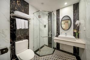 a bathroom with a shower and a toilet and a sink at Amara Hanoi Hotel and Spa in Hanoi