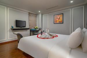 a hotel room with a white bed with a bird on it at Amara Hanoi Hotel and Spa in Hanoi