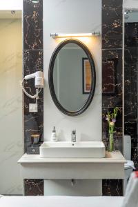 a bathroom with a sink and a mirror at Amara Hanoi Hotel and Spa in Hanoi