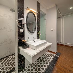 a bathroom with a sink and a mirror at Amara Hanoi Hotel and Spa in Hanoi